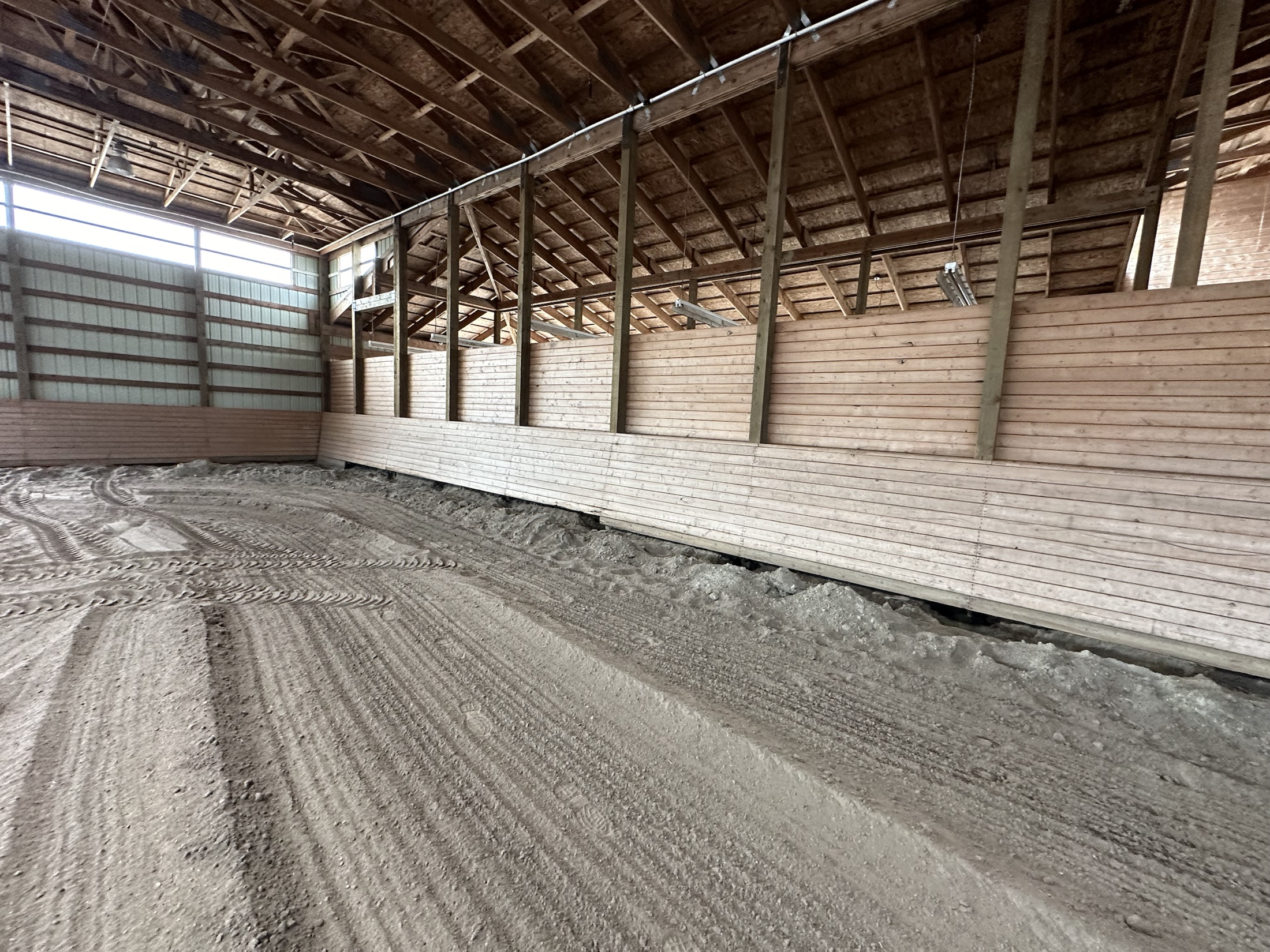 Finished tongue-and-groove kick wall along the arena interior at Coast Performance Horses, Langley