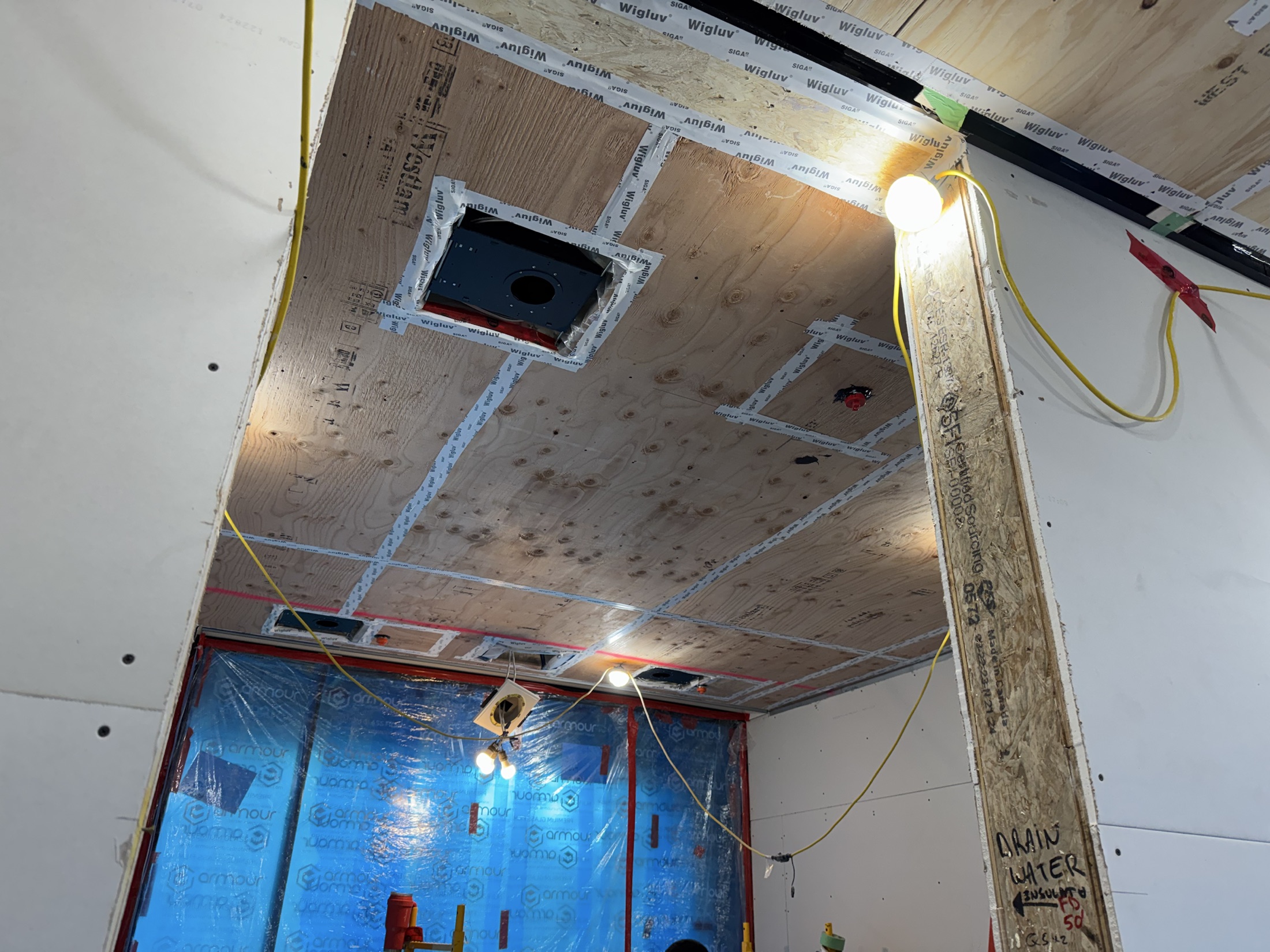 Cove Beach custom home ceiling before finishing — raw plywood substrate with taped air-sealing seams, Sechelt