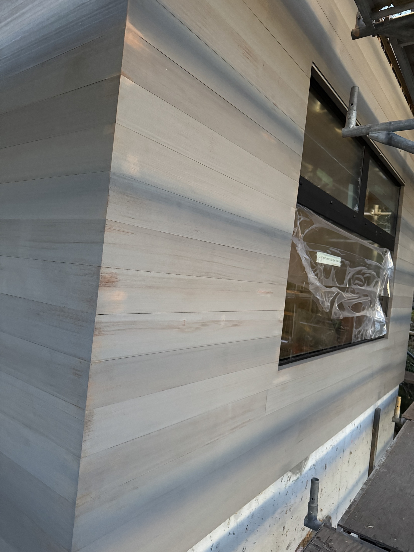 Cove Beach ADU, Sechelt — finished mitered cedar rainscreen siding corner meeting a window
