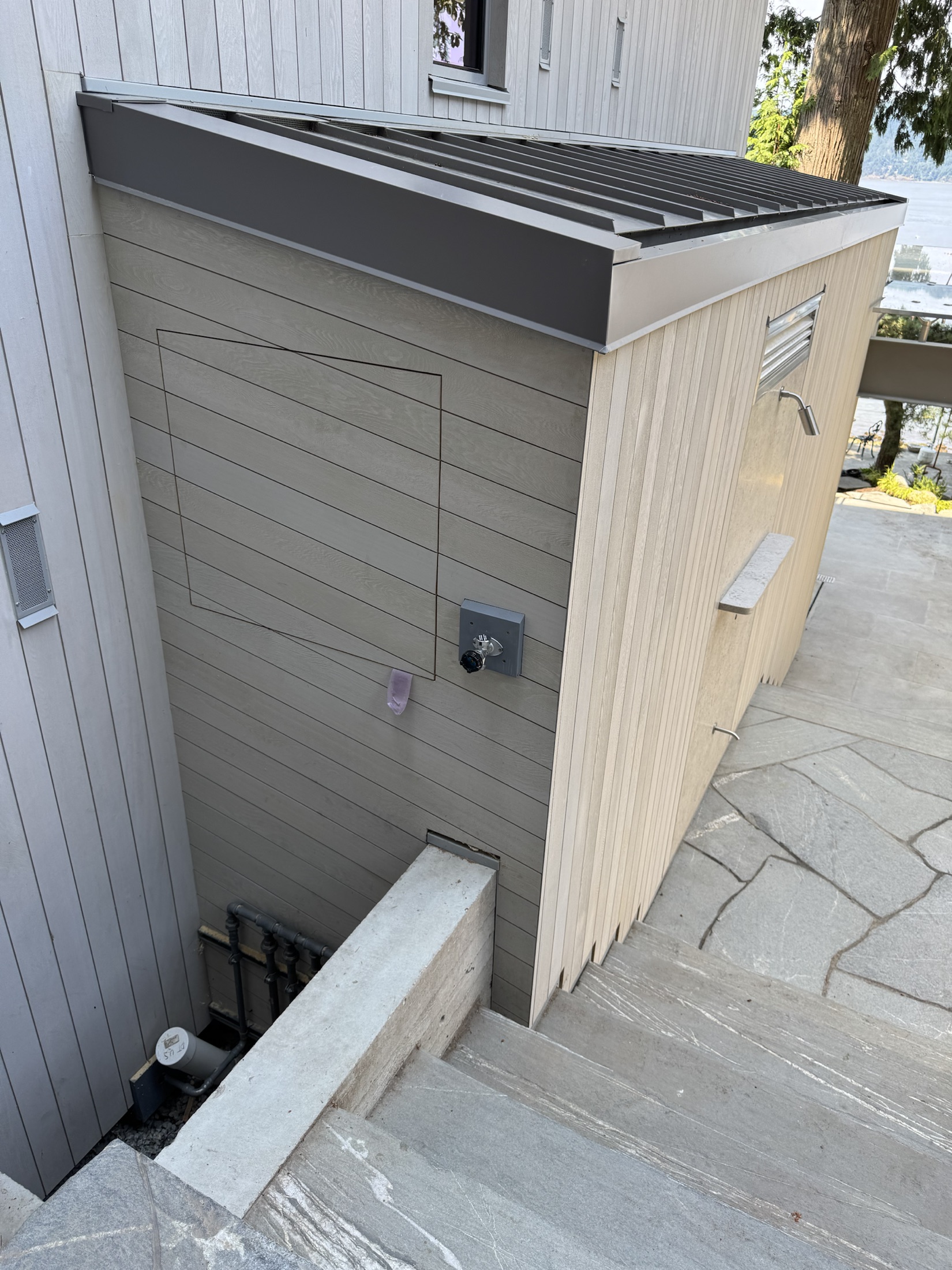 Finished cedar rainscreen siding on the Lawrence Way custom home in West Vancouver, with the waterfront beyond
