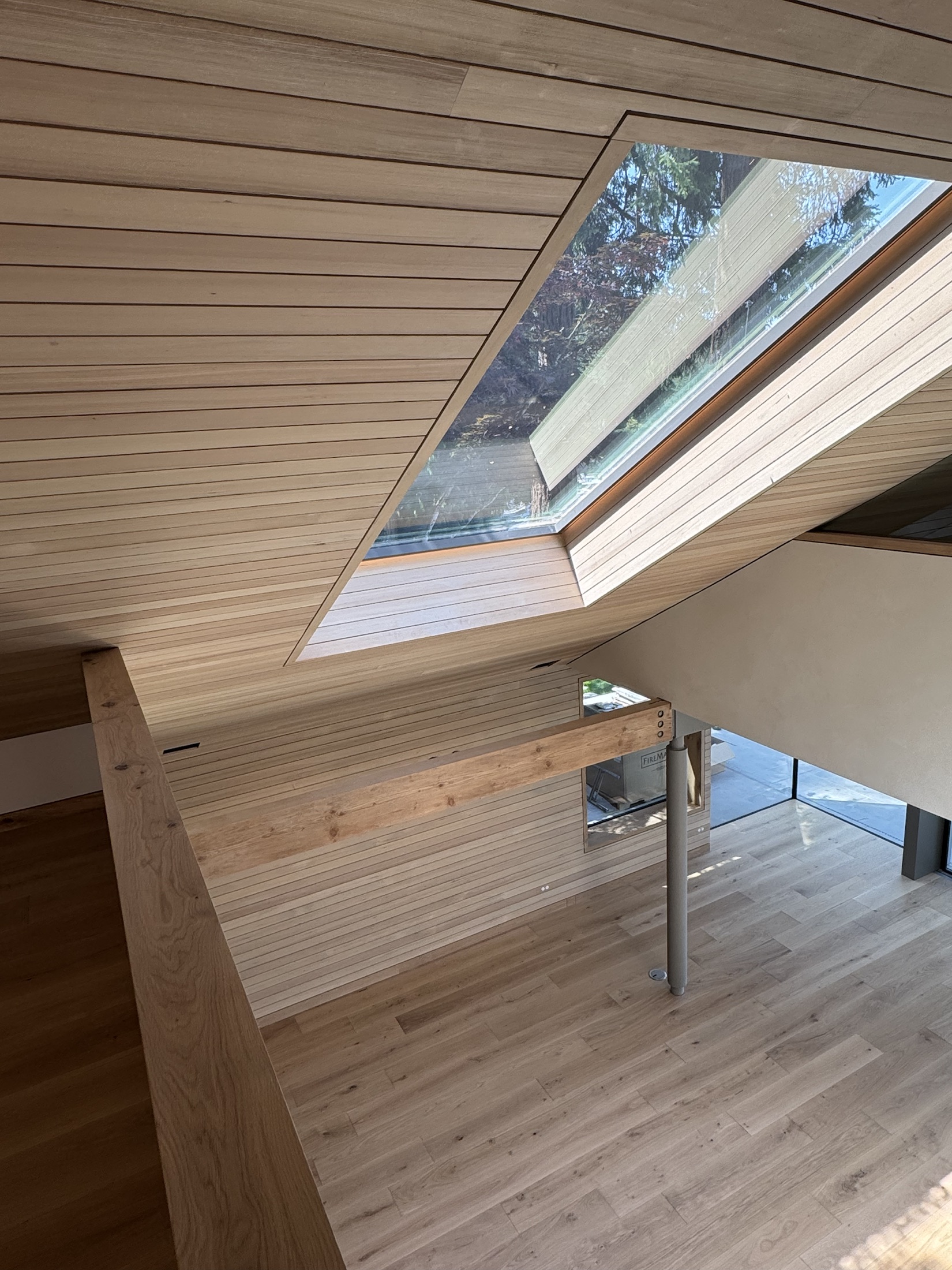 Lawrence Way custom home, West Vancouver — hemlock plank ceiling meeting an angled skylight, built exactly as modelled in the design-build phase