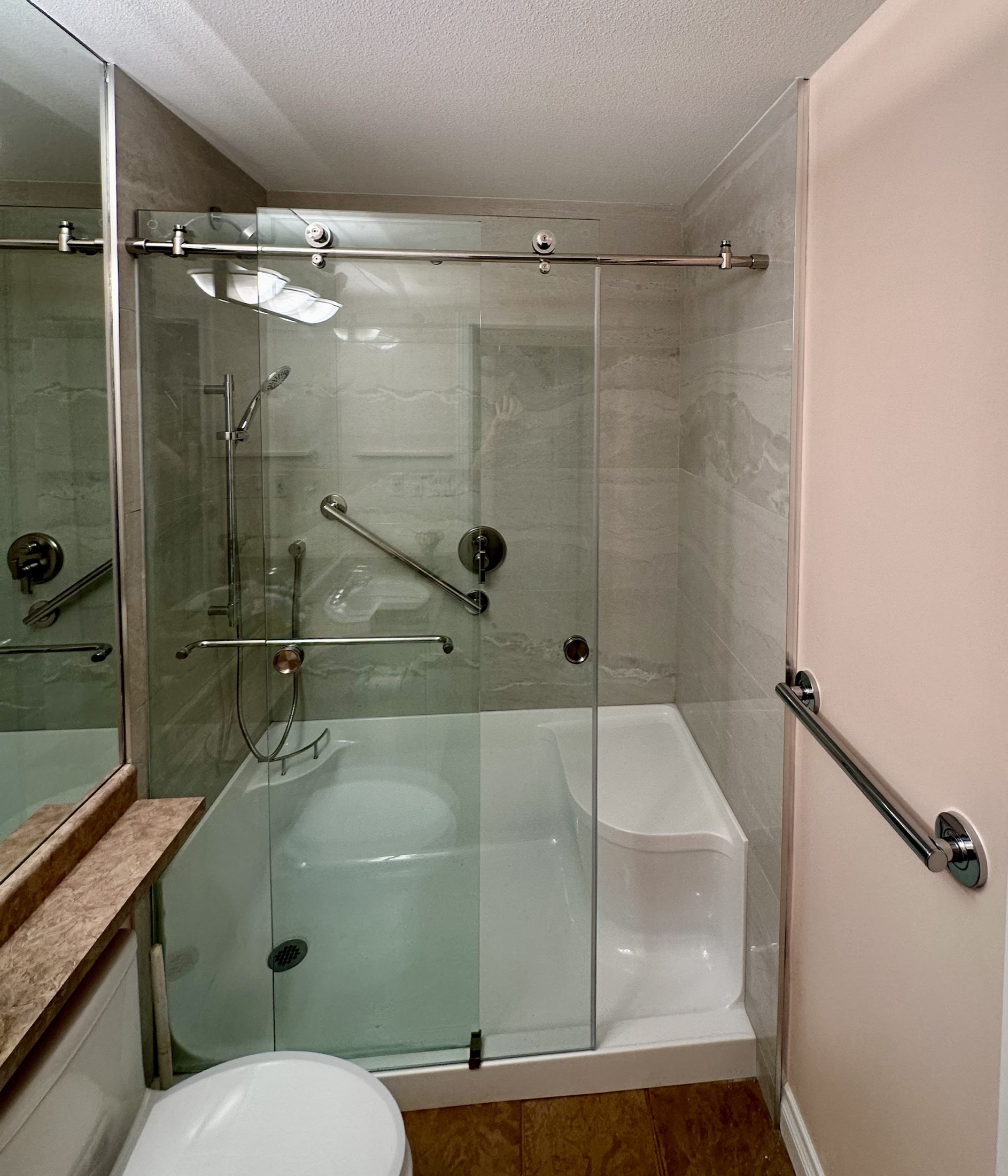 Paula Dhillon bathroom renovation, Surrey — finished frameless glass shower with integrated grab bar and bench