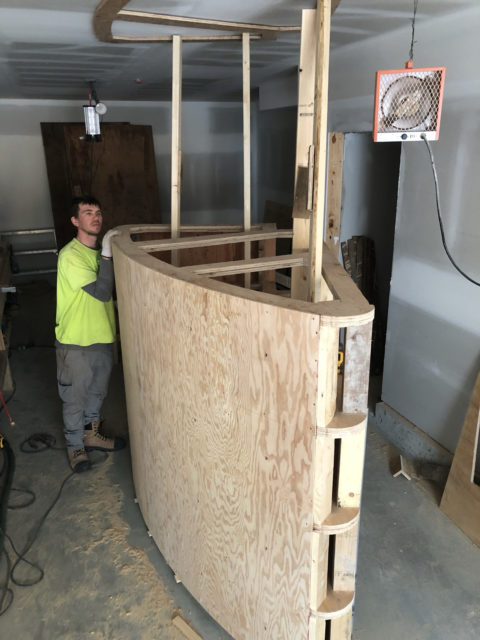 Renova crew member hand-building curved plywood formwork in-shop for the Pemberton curved concrete staircase