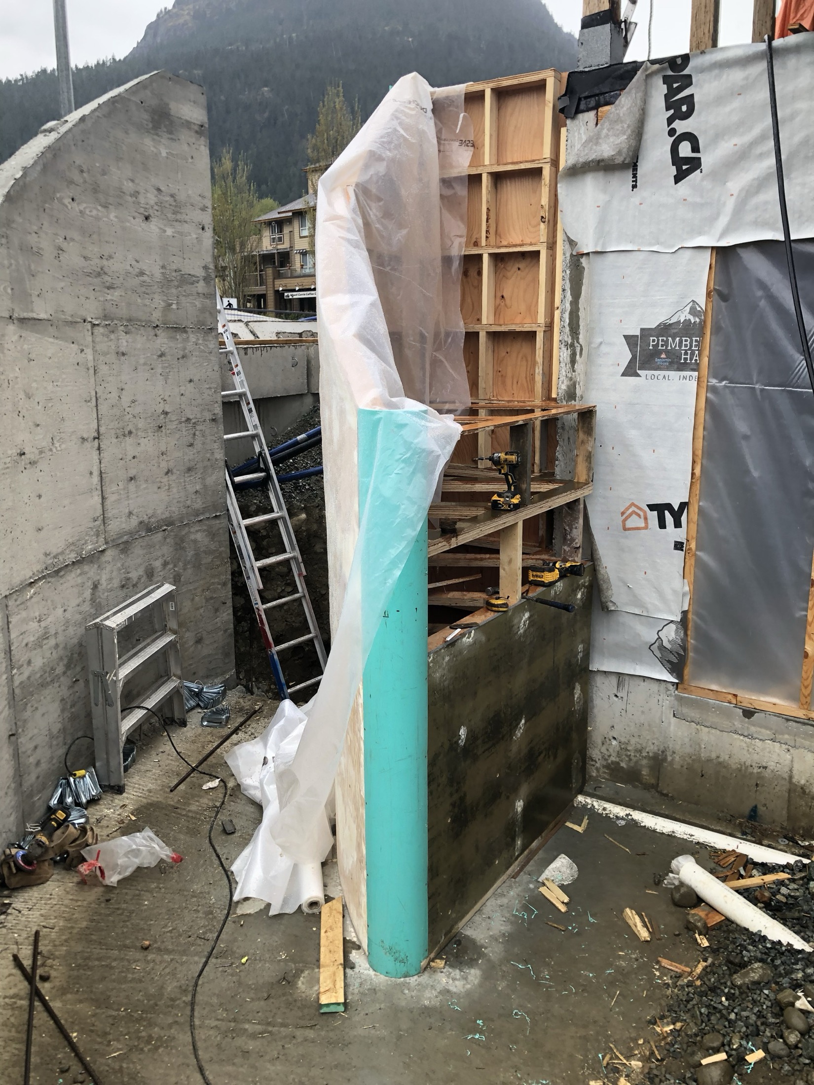 Curved concrete formwork being installed on-site for the Pemberton staircase, mountain backdrop