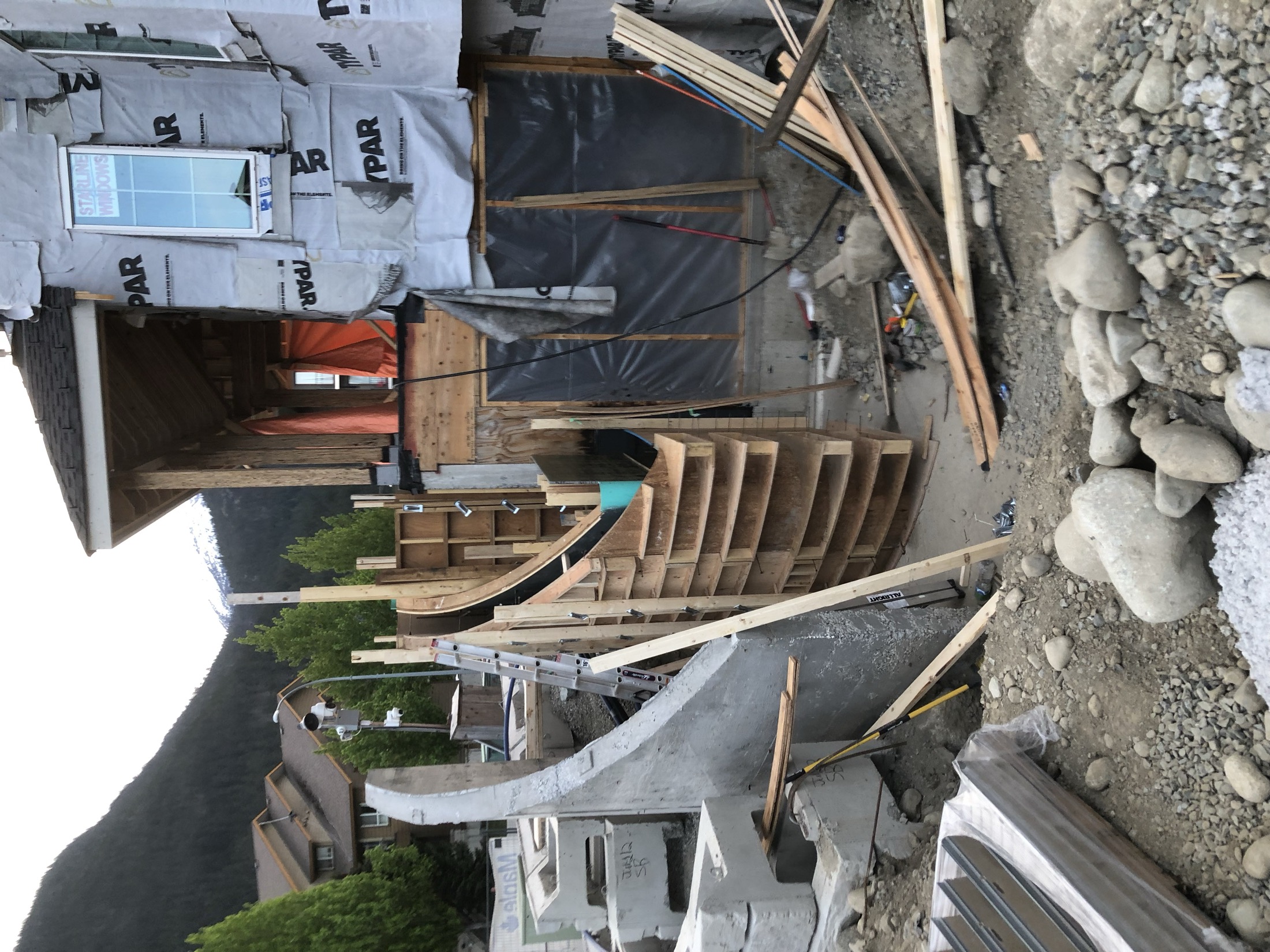 Wide on-site view of the curved concrete stair formwork installation on the Pemberton townhouse development