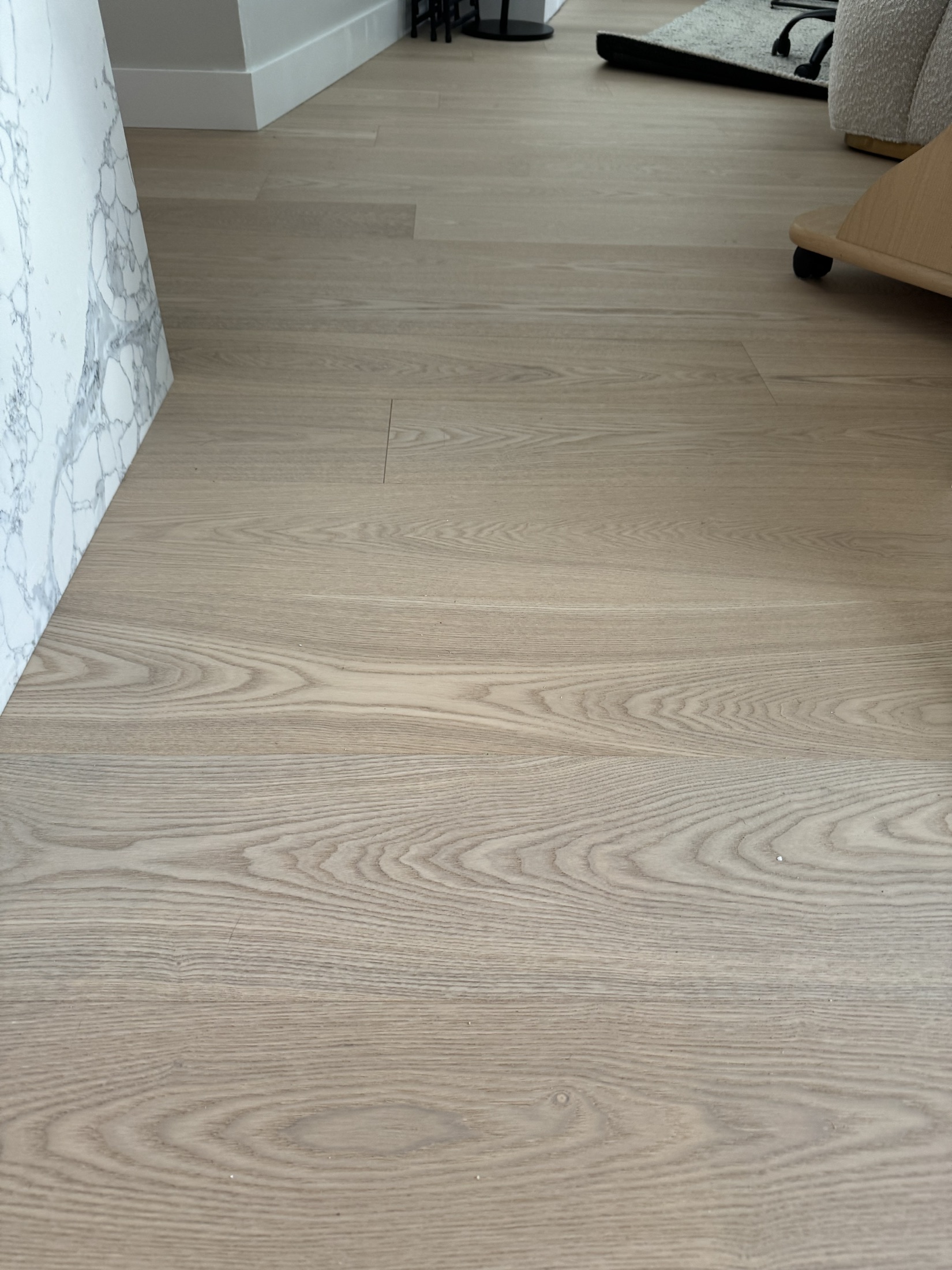 Wende's Remodel, New Westminster — new light wide-plank oak flooring beside a marble waterfall island edge