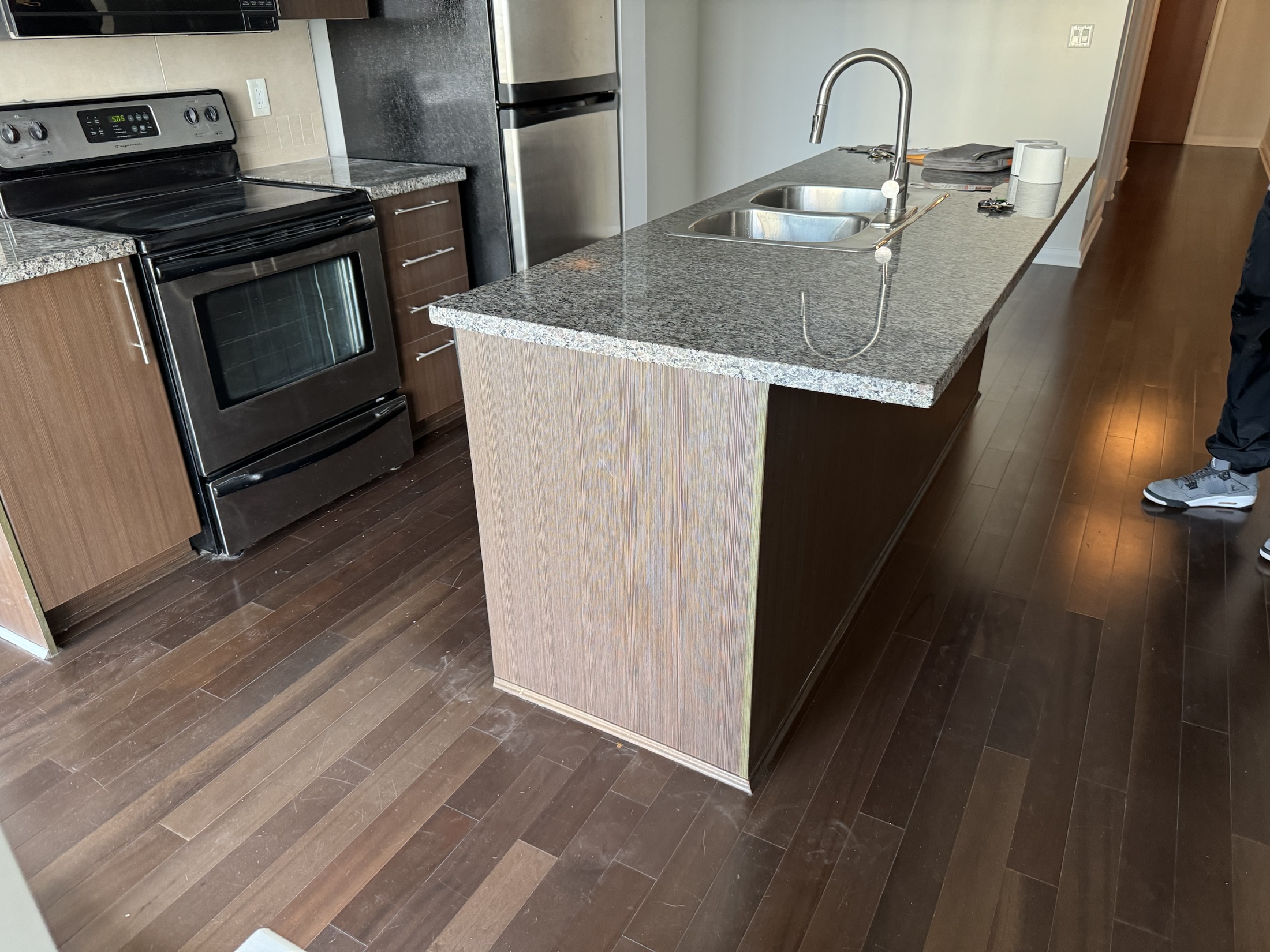 Wende kitchen before renovation in New Westminster — dark espresso cabinets, speckled granite and black appliances